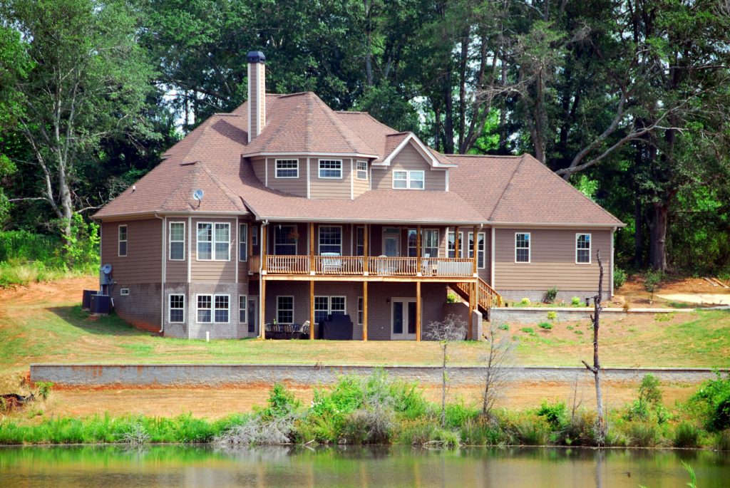 a two-story house in front a lake